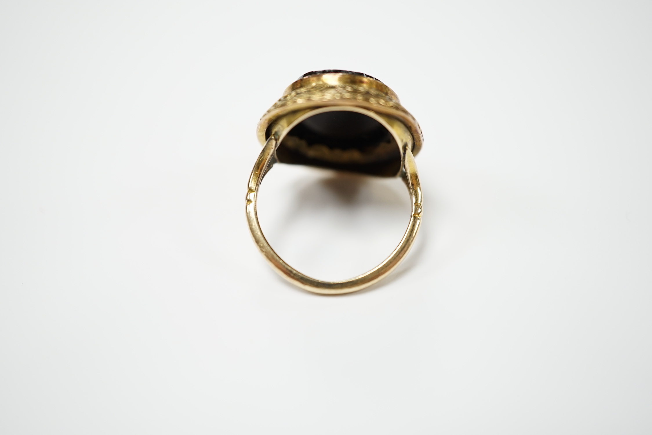 A 19th century yellow metal and oval micro mosaic set ring, depicting a warrior, size O.